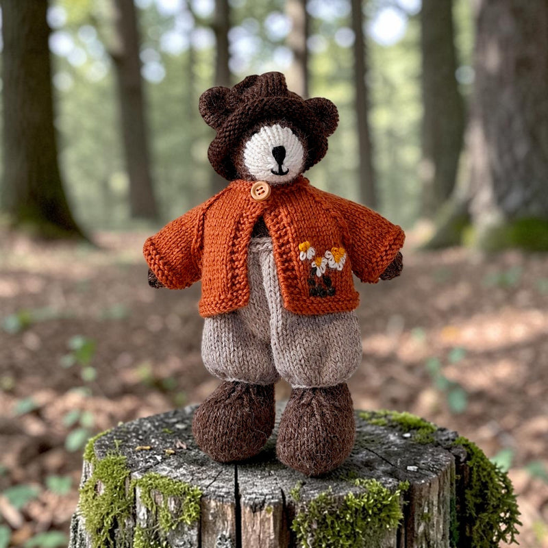 Pebblewood Resident wearing rust wool daisy cardigan in a woodland setting