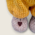 Close-up of Alder Finch's collectible handmade bear needle-felted heart on the right paw.