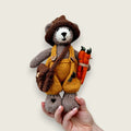 Alder Finch handmade Pebblewood collectible bear held in a hand to show his scale and size.