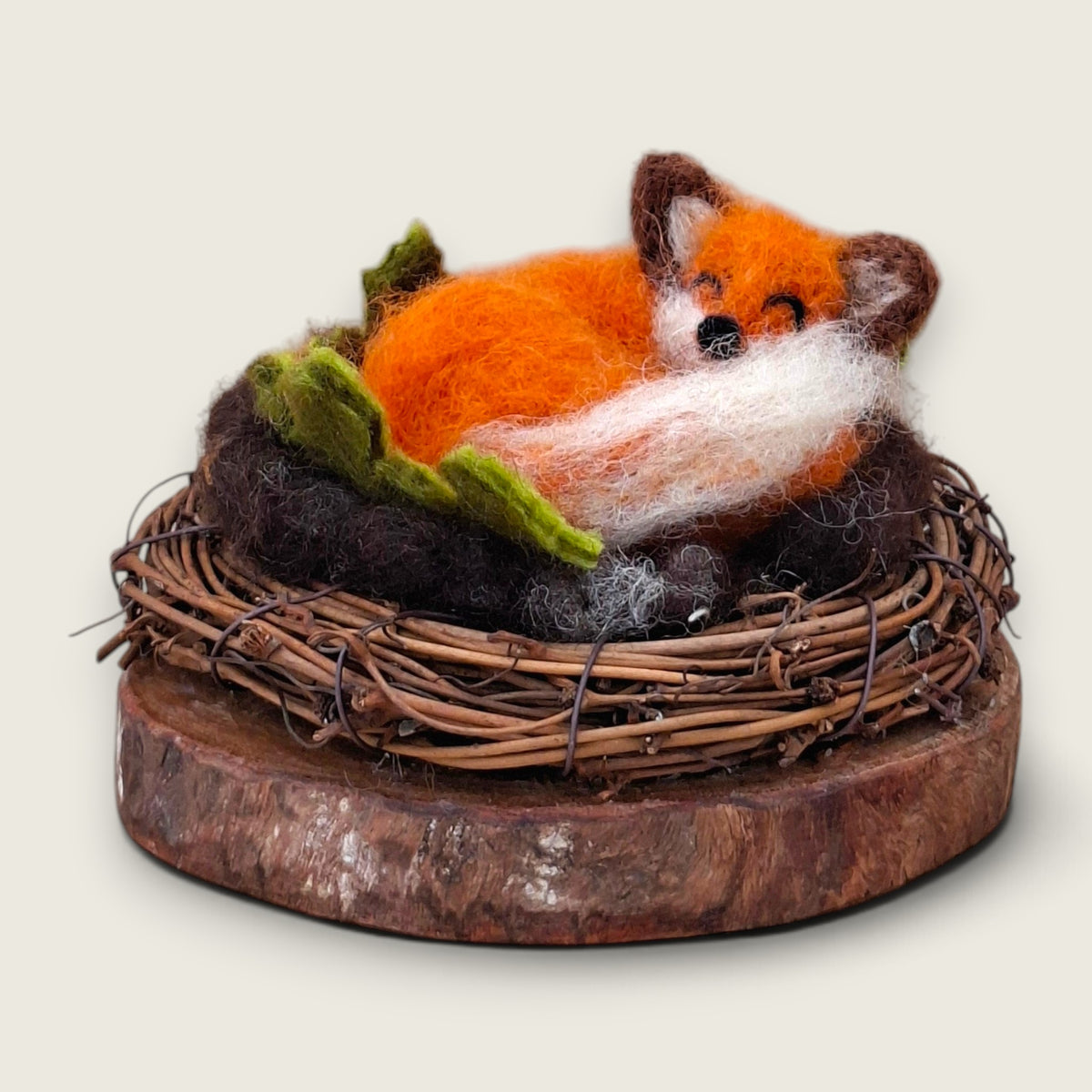 Autumn Rust, a needle felted sleeping fox curled in a twig wreath on a wood slice