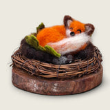 Autumn Rust, a needle felted sleeping fox curled in a twig wreath on a wood slice