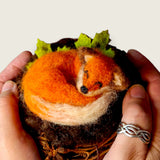 The sleeping fox held in two hands, showing the size of the piece