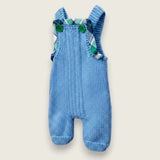 Side view of blue merino baby dungarees with printed tartan trim.