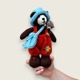 Bracken Moss handmade Pebblewood collectible bear held in a hand to show his scale and size.