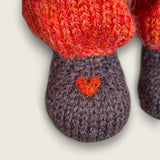 Close-up of the needle-felted heart detail on the right paw of Bracken Moss, a handmade Pebblewood collectible bear.