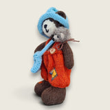 Left side view of Bracken Moss, a handmade Pebblewood collectible bear with hand-knitted clothing and needle-felted hedgehog accessory.