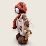 Left side view of Bramble Rowan handmade collectible bear showing knitted satchel and pointed hat.