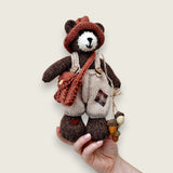 Bramble Rowan handmade Pebblewood collectible bear held in a hand to show his scale and size.