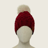 The burgundy hat on a mannequin, showing its full shape from brim to pompom