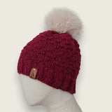 Side view of the burgundy textured hat, showing the leatherette tag at the brim
