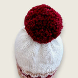Back view of the colourwork hat, showing the burgundy band and pompom