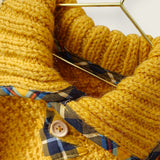 Mustard wool jumper collar showing printed tartan trim and wooden buttons.