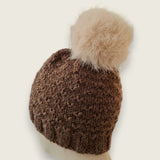 Back view of the dark brown hat, showing the textured stitch and pompom