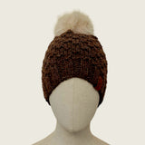 Dark brown handknitted alpaca and wool hat with a mink-coloured faux fur pompom, front view