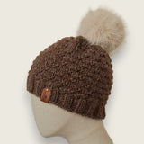Side view of the dark brown textured hat, showing the leatherette tag at the brim
