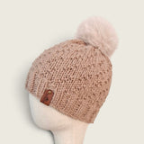 Side view of the fawn knitted hat, showing the leatherette tag at the brim