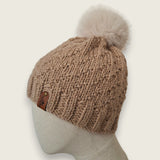 Side view of the fawn textured hat, showing the leatherette tag at the brim
