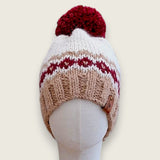 Fawn and burgundy colourwork alpaca and wool hat with a burgundy pompom, front view