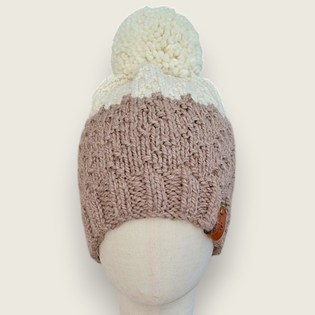 Fawn and natural handknitted alpaca and wool hat with a natural pompom, front view