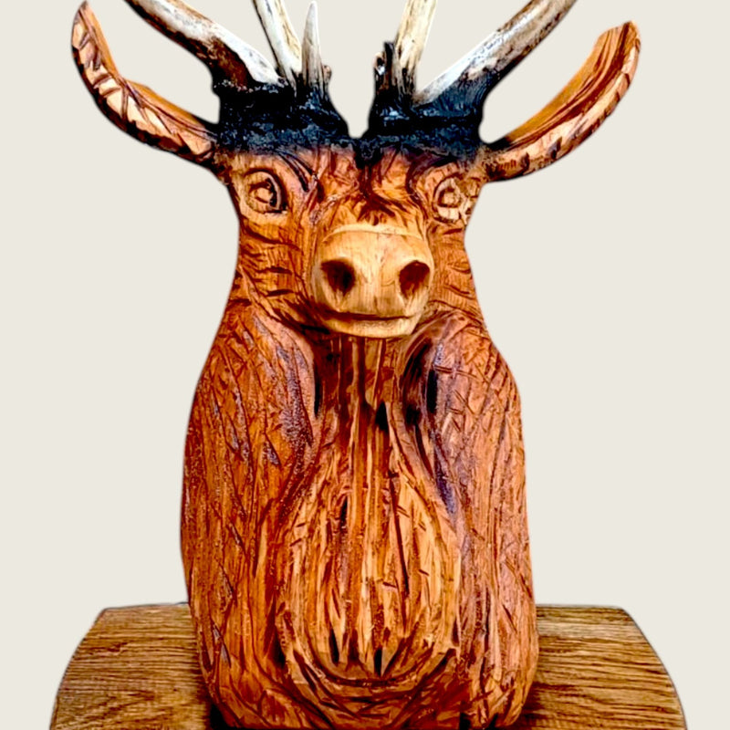 Close view of the carved stag's face and the chisel marks in the lime wood