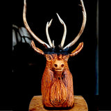 The carved stag lit against a black background