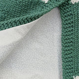 Close-up of cotton floral lining inside green merino wool capelet