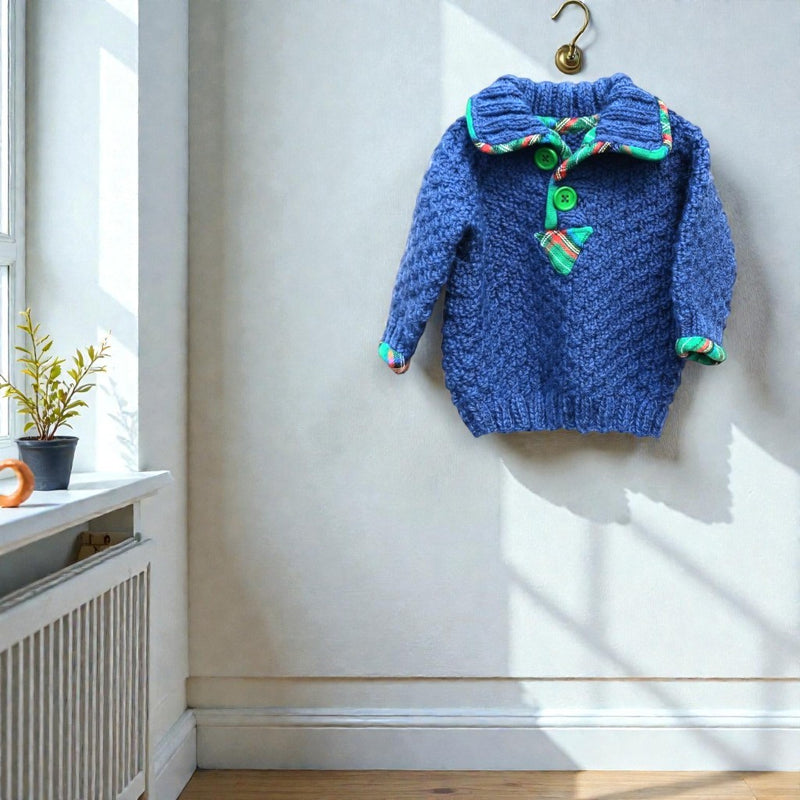 Hand knitted blue alpaca wool baby jumper lifestyle shot hanging on wall - alpaca and wool blend knitwear handmade in the Boyne Valley Co. Meath Ireland