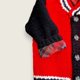 Close-up of tartan sleeve lining on red and black handknitted alpaca wool toddler jacket
