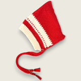 Red and ivory handknitted merino wool baby bonnet with ties and tartan detail.