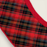 Close-up of printed tartan lining inside a handknitted red merino wool baby capelet.