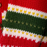Close-up of green, white and red knitted colourwork on merino cardigan