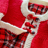 Close-up of tartan buttons and neckline on red merino baby matinee coat