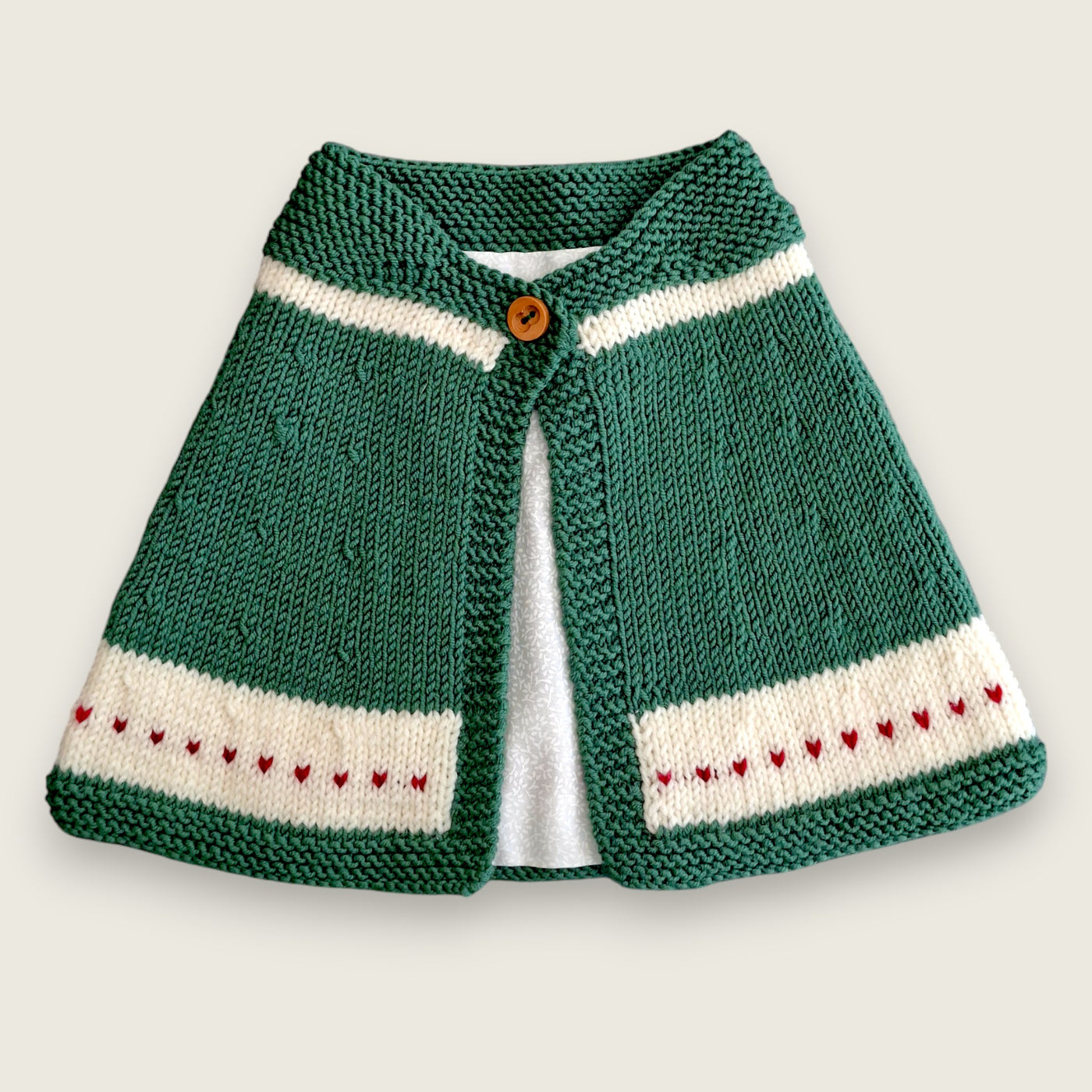 Green merino wool capelet with ivory bands and red intarsia hearts