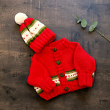 Red merino newborn cardigan and matching hat styled on dark wood