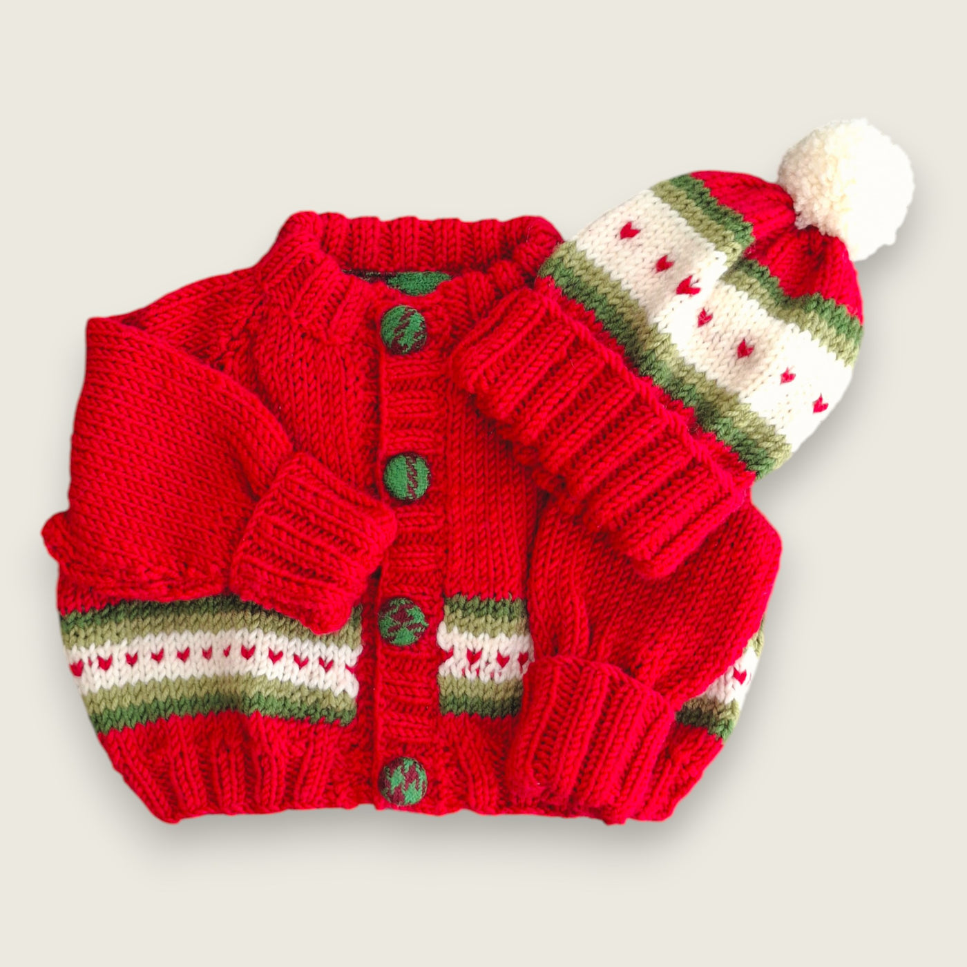 Red 100% merino wool newborn cardigan and hat showing coordinating heart detail