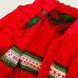 Close-up of red merino cardigan showing tartan trim and knitted heart detail