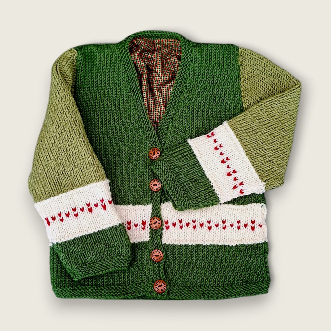 Green merino wool toddler cardigan with heart detail and printed check lining