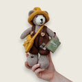 Hazel Hollow handmade Pebblewood collectible bear held in a hand to show his scale and size.