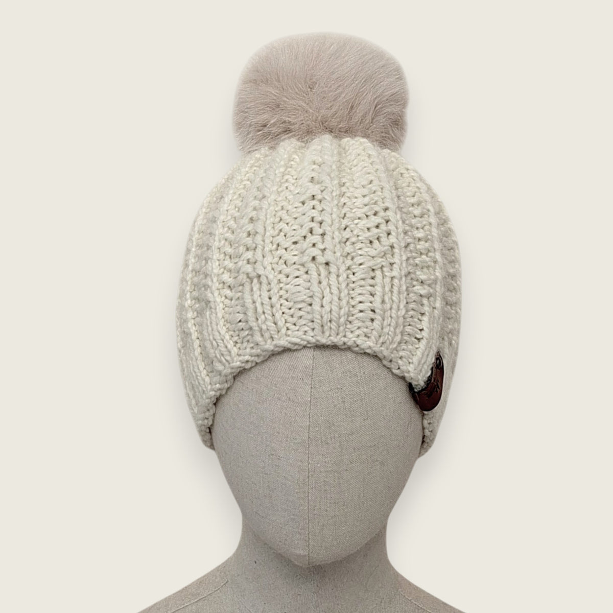 Natural handknitted alpaca and wool hat with a mink-coloured faux fur pompom, front view