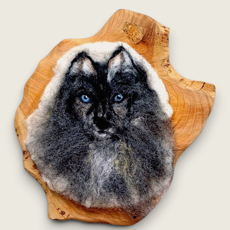 Needle-felted grey wolf portrait with blue eyes on a natural live-edge wooden base, handmade by The Crafty Pebblers in Ireland.