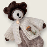 Close-up of ecru wool bear cardigan with hand-embroidered flower