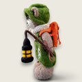 Left side view of Pip Elder, a hand-knitted Pebblewood collectible bear wearing green dungarees, round glasses, knitted hat and scarf.