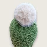 Back view of the sage green hat, showing the textured stitch and pompom