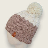 Side view of the fawn and natural textured hat, showing the leatherette tag at the brim