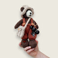 Swallow Flight handmade Pebblewood collectible bear held in a hand to show his scale and size.