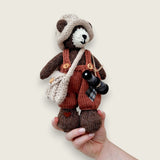Swallow Flight handmade Pebblewood collectible bear held in a hand to show his scale and size.