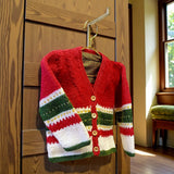 Handknitted merino wool cardigan in red, green and white with tartan trim.