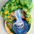 Overhead view of The Living Fall 3D felted wool sculpture, showing the waterfall, swirling pool, needle-felted rock face and woodland details.
