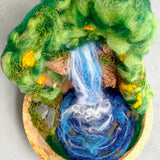Overhead view of The Living Fall 3D felted wool sculpture, showing the waterfall, swirling pool, needle-felted rock face and woodland details.