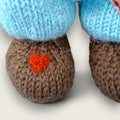 Close-up of the needle-felted heart detail on the right paw of Thorne Ash, a hand-knitted Pebblewood collectible bear.